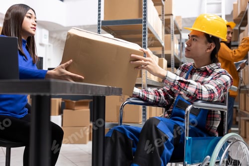 Preview: Asian male person with reduced mobility handling merchandise boxes