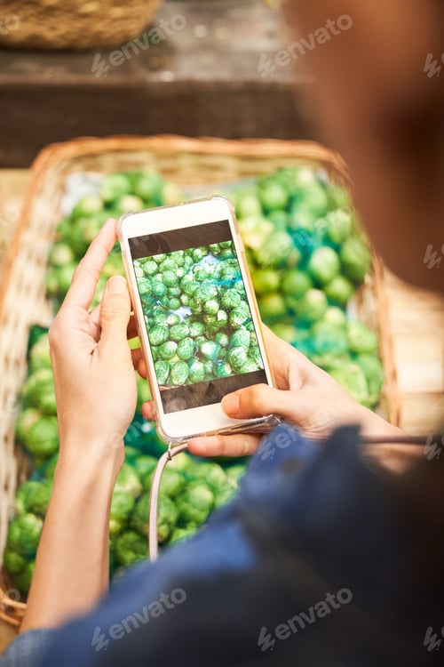 Preview: Anonymous person taking photo of ripe artichokes