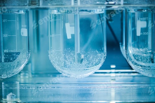 Preview: Close up of beakers containing liquid in a contained labratory