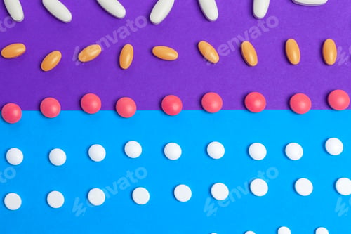 Preview: A pile of multicolored pills on blue background. Top view
