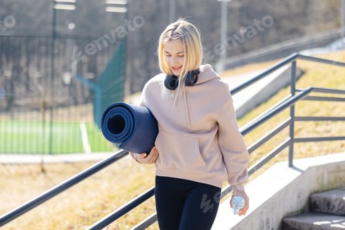 Preview: Attractive Woman with Yoga Mat outdoors