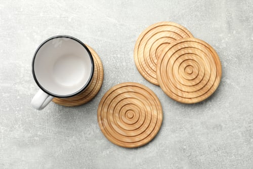 Preview: Mug and stylish wooden coasters on light grey table, flat lay