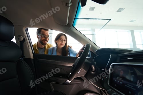 Preview: Loving couple choosing new auto in car center