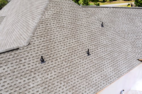 Preview: Roofing installation showcased on large residential building under clear blue sky during works day