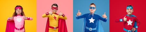 Preview: Cheerful kids in superhero costumes showing thumbs up