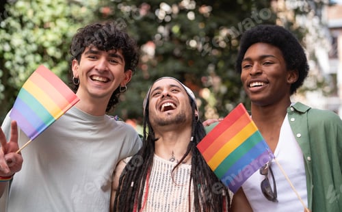 Preview: Happy multiethnic friends celebrating gay pride holding rainbow flags