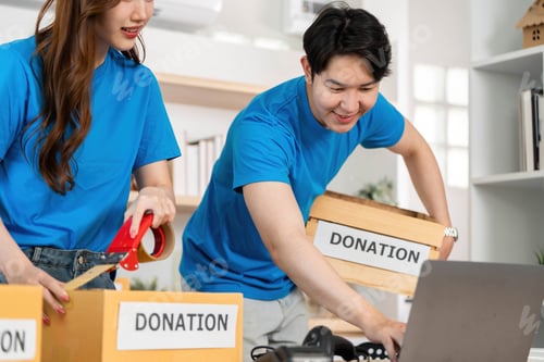 Preview: Donation Activity. Volunteers collaborating to pack donation boxes at a community center.