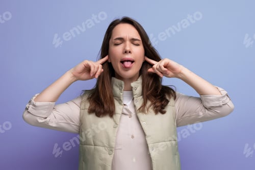 Preview: young brunette woman showing with grimace showing tongue