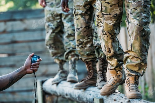 Preview: partial view of tactical instructor with stop watch examining multiracial soldiers during obstacle