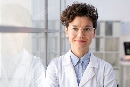 Preview: Young successful female worker of scientific lab in whitecoat and eyeglasses