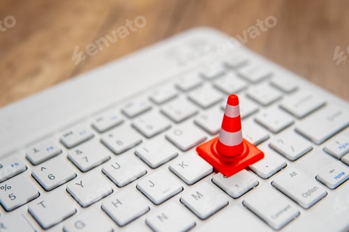 Preview: A miniature traffic cone placed on a computer keyboard.