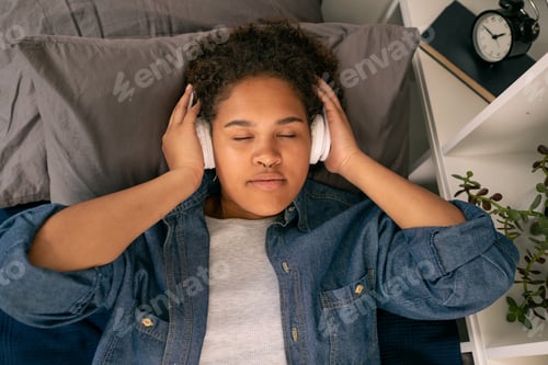 Preview: Teenage girl listening to relaxation music before sleep
