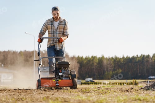 Preview: Man using aerator machine to scarification and aeration of lawn or meadow