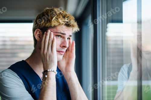 Preview: Close-up of sad and frustrated young man indoors at home