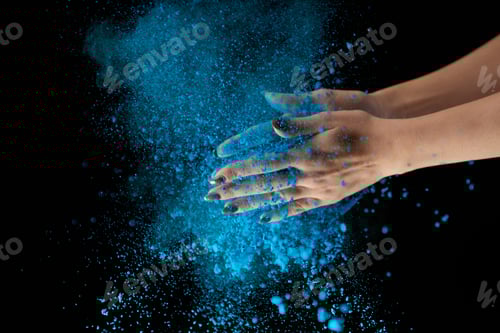 Preview: cropped view of adult woman holding blue holi powder and clapping on black background