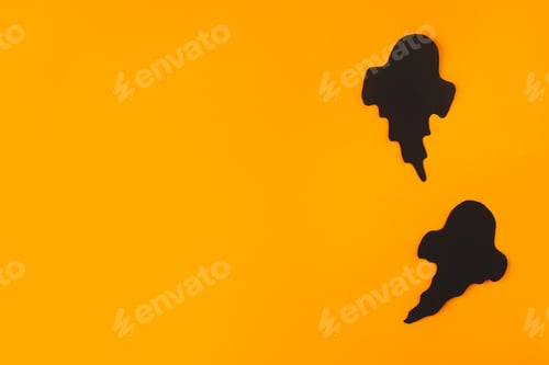 Preview: Halloween flat lay. Black ghosts on orange background. Happy Halloween, minimal card