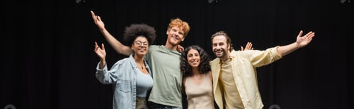 Preview: troupe of smiling multicultural actors hugging and waving hands in theater, banner