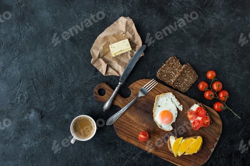 Preview: flat lay with tasty healthy breakfast on wooden cutting board on dark tabletop