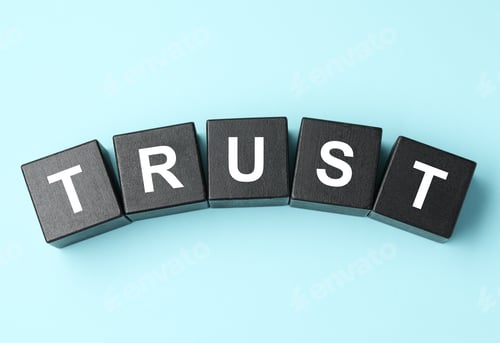 Preview: Word Trust made of black cubes on light blue background, flat lay