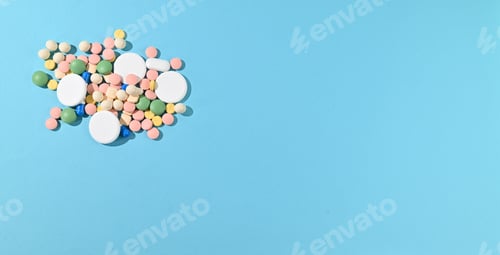 Preview: Colorful assortment of various antibiotic pills and tablets on a blue background