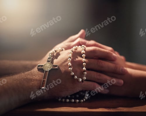 Preview: Cropped shot of two people praying while holding a rosary