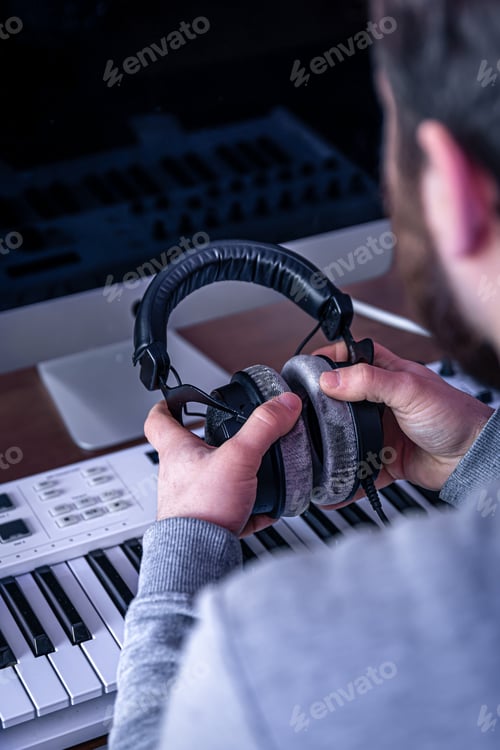 Preview: Audio Producer Holding Headphones in Recording Studio