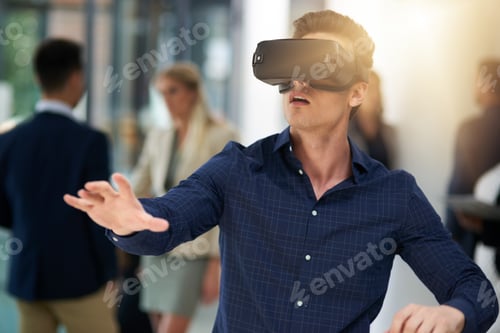 Preview: Immersed in a virtual world. Shot of a young businessman wearing a VR headset in a busy office.