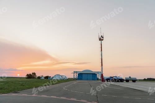 Preview: Small airport on sunset, runway with hangar in background.