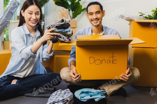 Preview: Asian volunteer man and woman packing cloth box and donate to other people and share to charity