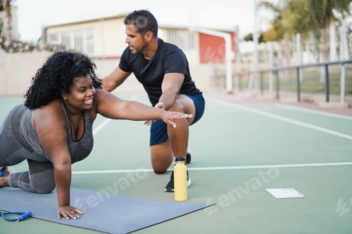 Preview: African curvy woman and personal trainer doing pilates workout session outdoor