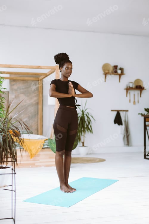 Preview: Vertical calm, cheerful, smiling and meditating interracial, multicultural woman practicing yoga