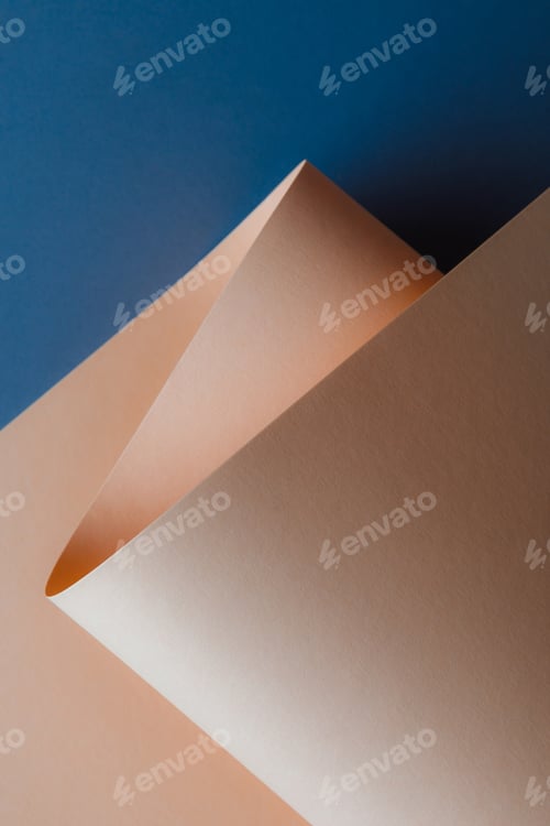 Preview: close-up view of beautiful tender beige paper sheet on dark blue background