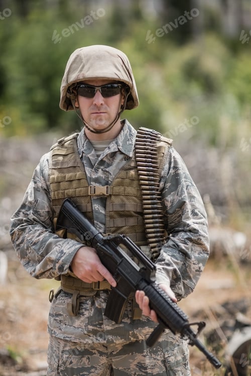 Preview: Confident military soldier standing with rifle