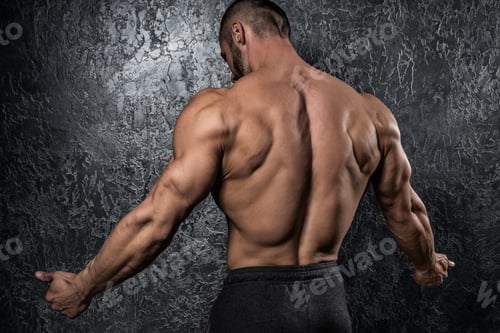 Preview: Man showing muscular back against conctete wall