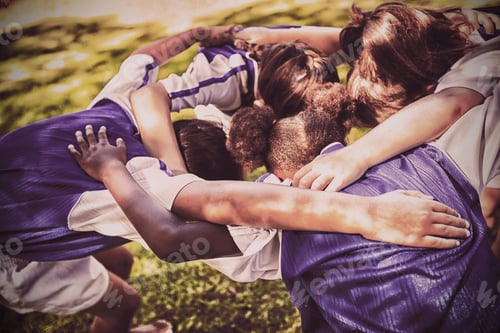 Preview: Rear view of soccer team forming huddle
