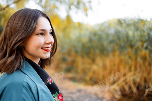 Preview: Autumn vibes. Beautiful young relaxed woman in blue coat enjoying nature breathing fresh air meditat