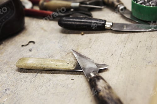 Preview: Close up of knives on bench in shoe makers workshop