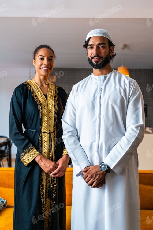 Preview: Happy beautiful young arab couple with emirati clothing together at home