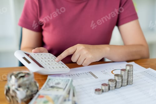Preview: Saving concept the woman in a red top calculating monthly expense and income by using the calculator