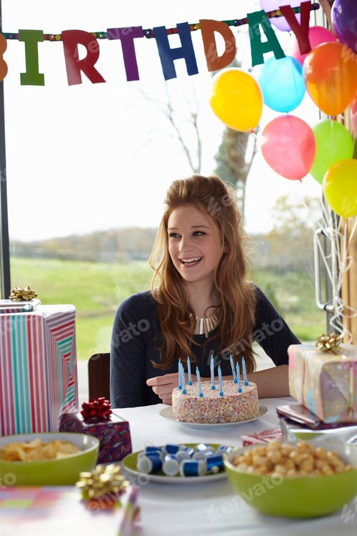 Preview: Teenage girl at table with birthday cake