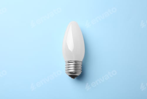 Preview: New modern lamp bulb on light blue background, top view
