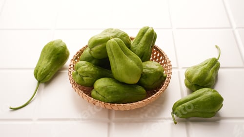 Preview: A pile of green chayote squash on bamboo plate