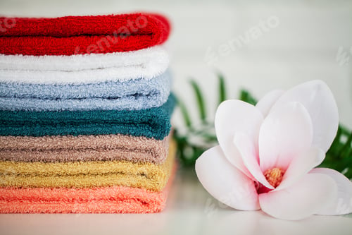 Preview: Towels and a branch of an orchid on a white background. Aromatherapy. Spa and Hygiene