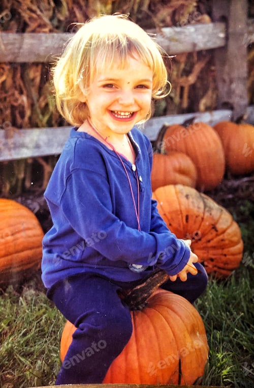 Preview: Cute child in an autumn pumpkin patch
