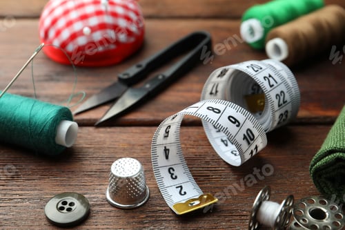 Preview: Threads and other sewing supplies on wooden table, closeup