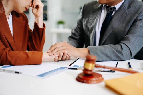 Preview: Professional lawyer comforting client during legal consultation in modern office,