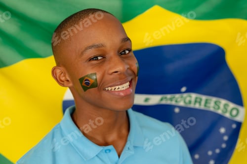 Preview: Portrait of happy african american male teenager with flag of brazil