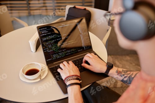 Preview: Male Programmer Using Laptop Writing Code at Cafe Table during Coffee Break
