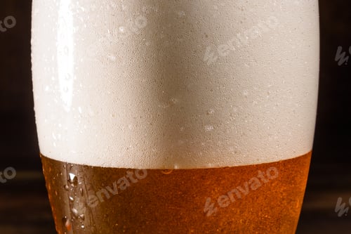 Preview: Glass of light beer on a dark pub