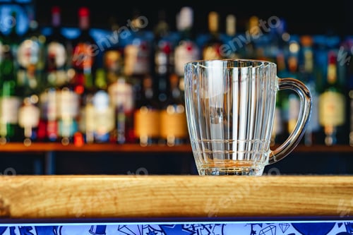 Preview: Empty beer glass on a wooden bar counter